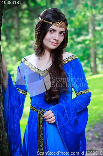 Image of beautiful princess standing near big tree