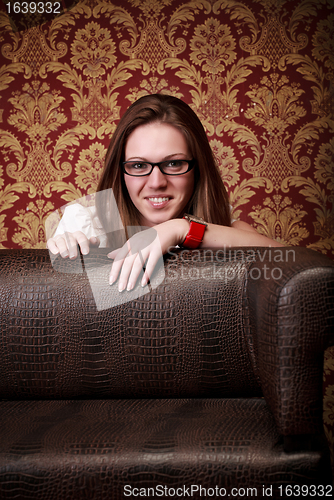 Image of girl peeping out from sofa