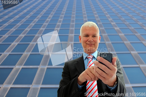 Image of Businessman writing on his mobile phone