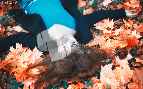 Image of Girl Lying in Autumn Leaves