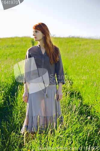 Image of sad redhead woman in grass