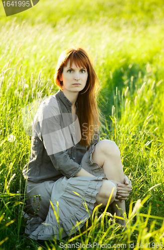 Image of sad redhead woman in grass