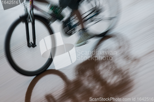 Image of Boy on bicycle reflecting in puddle