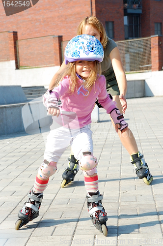 Image of city park family rolleblading on roller skates together