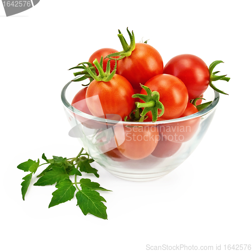 Image of Tomatoes in a glass container with a green leaf