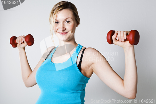 Image of Pregnant woman exercising with dumbbells