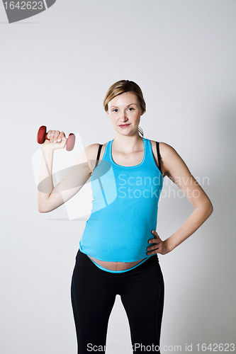 Image of Pregnant woman exercising with dumbbells