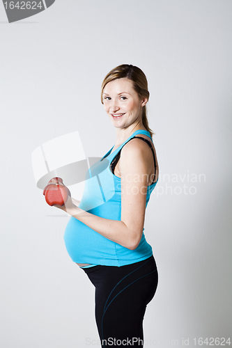 Image of Pregnant woman exercising with dumbbells