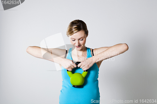 Image of Pregnant woman exercising with kettlebell