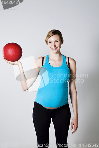 Image of Pregnant woman exercising with exercise ball