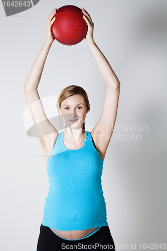 Image of Pregnant woman exercising with ball