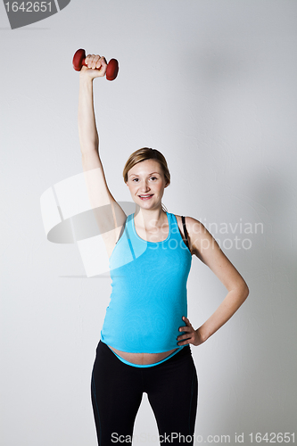 Image of Pregnant woman exercising with dumbbells