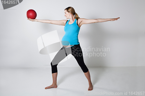 Image of Pregnant woman exercising with exercise ball