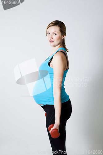 Image of Pregnant woman exercising with dumbbells