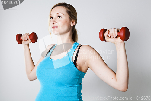 Image of Pregnant woman exercising with dumbbells