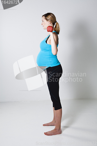 Image of Pregnant woman exercising with dumbbells