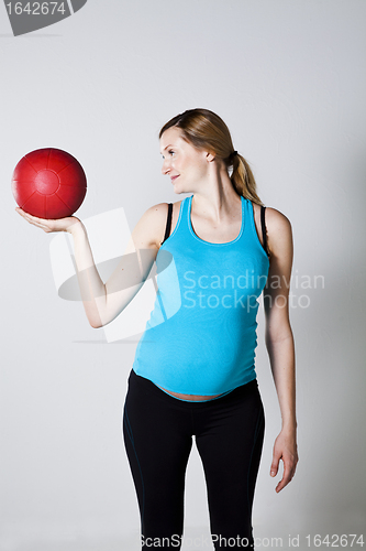 Image of Pregnant woman exercising with exercise ball