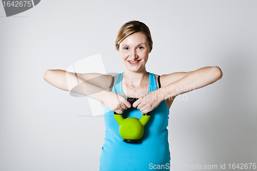 Image of Pregnant woman exercising with kettlebell