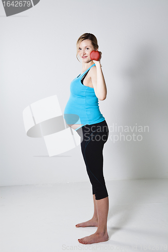 Image of Pregnant woman exercising with dumbbells