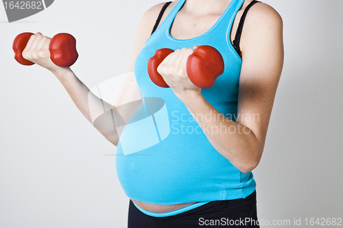 Image of Pregnant woman exercising with dumbbells