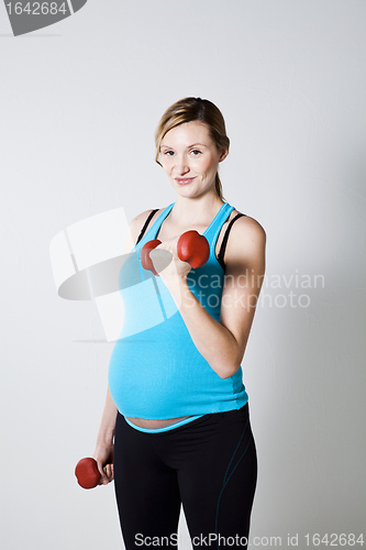 Image of Pregnant woman exercising with dumbbells