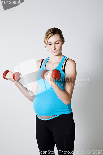 Image of Pregnant woman exercising with dumbbells