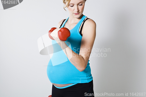 Image of Pregnant woman exercising with dumbbells