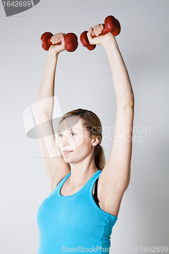 Image of Pregnant woman exercising with dumbbells