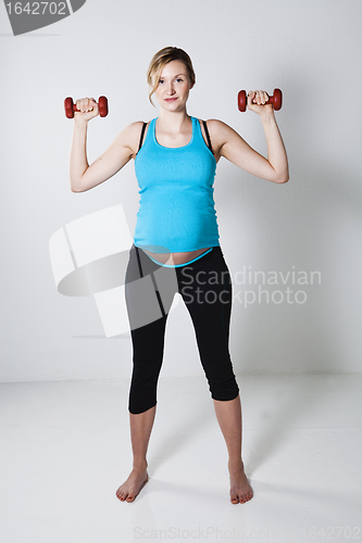 Image of Pregnant woman exercising with dumbbells