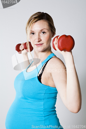 Image of Pregnant woman exercising with dumbbells