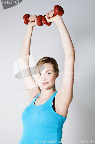 Image of Pregnant woman exercising with dumbbells