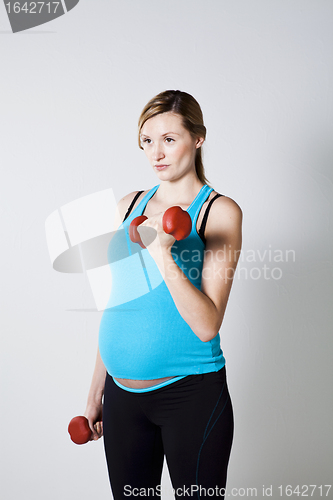 Image of Pregnant woman exercising with dumbbells