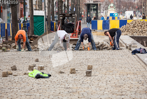 Image of Workmen rebuild cobbled street in Brussels