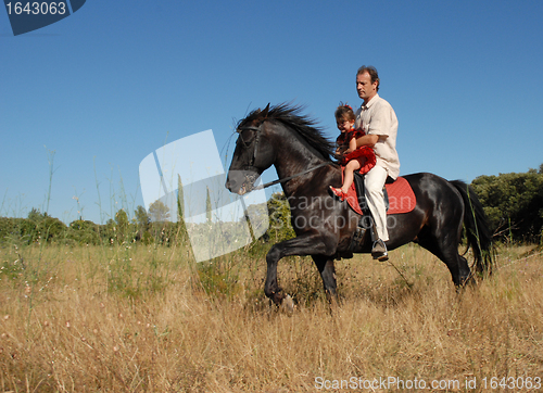 Image of father and daughter on horse