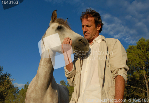 Image of man and grey horse