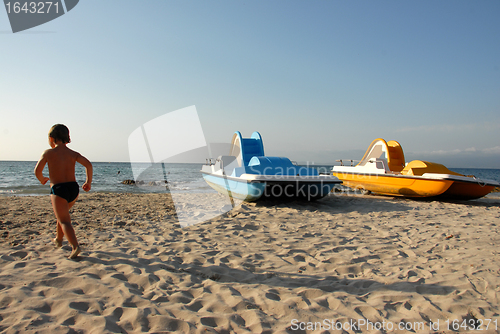 Image of beach, boy and pedalos