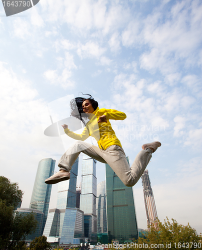 Image of brunette in a yellow blazer jumping