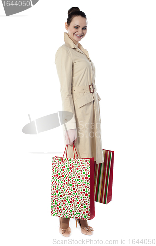 Image of Beautiful happy shopping woman holding shopping bags