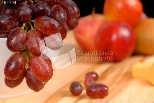 Image of Close up view of delicious fruit and cheese on cutting board
