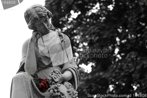 Image of Granite statue of woman holding a red rose at gravesite