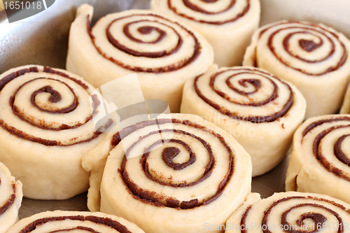 Image of Raw cinnamon buns ready to bake with selective focus.