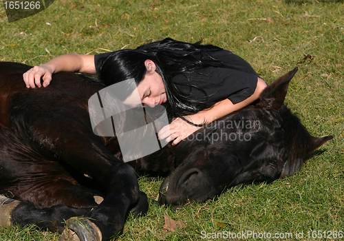 Image of horse laid down and riding girl