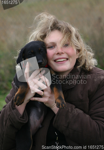 Image of puppy beauceron and woman