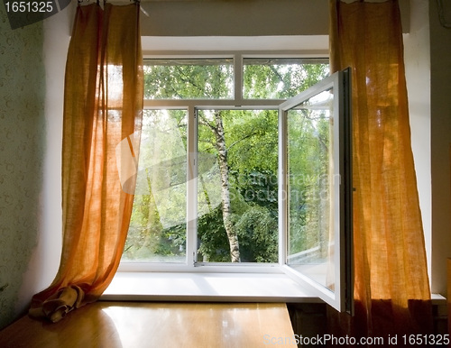 Image of Opened plastic window in room with view to green trees