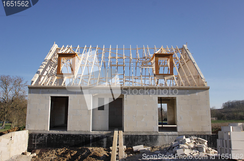 Image of house under construction with the roof structure of wood