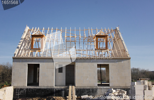 Image of house under construction with the roof structure of wood