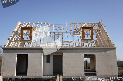 Image of house under construction with the roof structure of wood