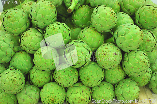 Image of large fresh artichokes on a market stall