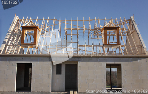 Image of house under construction with the roof structure of wood