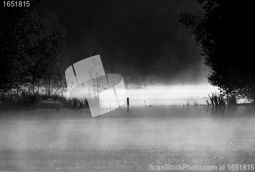 Image of black and white landscape of a small lake in the morning mist